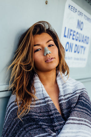 Woman wearing sunscreen on her nose to protect her nose from harmful exposure to the sun.